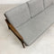 Gray sofa with wooden armrests on a light gray floor