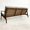 Wooden sofa with wicker backrest on a white background