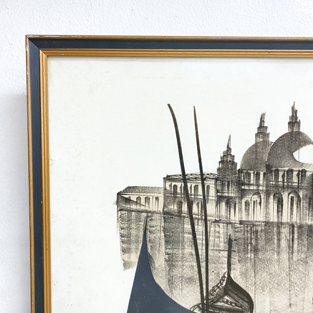 Framed artwork of a cityscape with domes and a boat on a river.