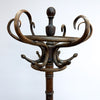 An antique dark brown wooden coat rack with ornate curved scrollwork and multiple hooks, photographed against a plain white background.