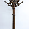A dark brown wooden coat rack with a central post, a decorative ring, and multiple curved hanging arms, shown against a plain white background.