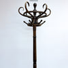 A vintage dark brown wooden coat rack with multiple curved hooks on a central pole, photographed against a plain white background.