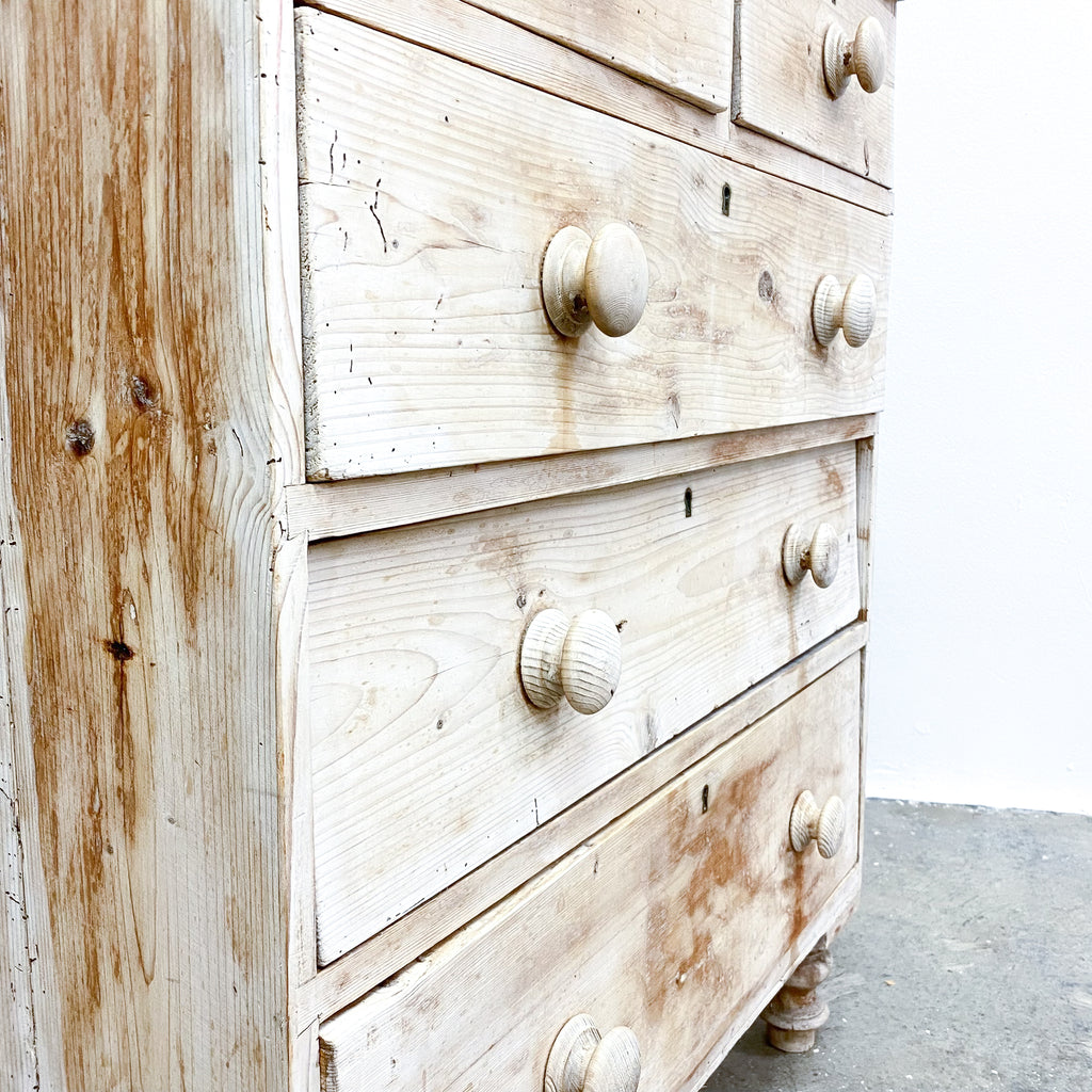 Wooden dresser with white-painted finish and visible grain texture.