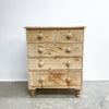 Wooden dresser with multiple drawers on a plain background