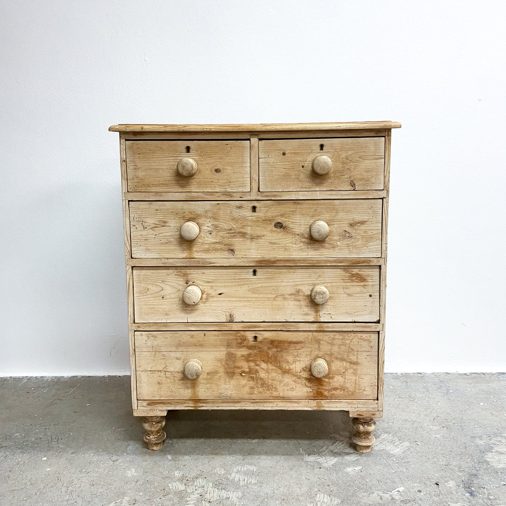 Wooden dresser with multiple drawers on a plain background