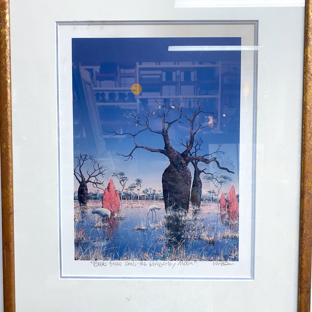 Framed artwork of trees and a building with a blue sky.