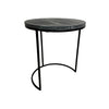 A round side table with a dark gray marble top and a black metal frame with a curved base, set against a plain white wall and concrete floor.