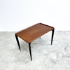 Wooden coffee table with black legs on a light gray floor