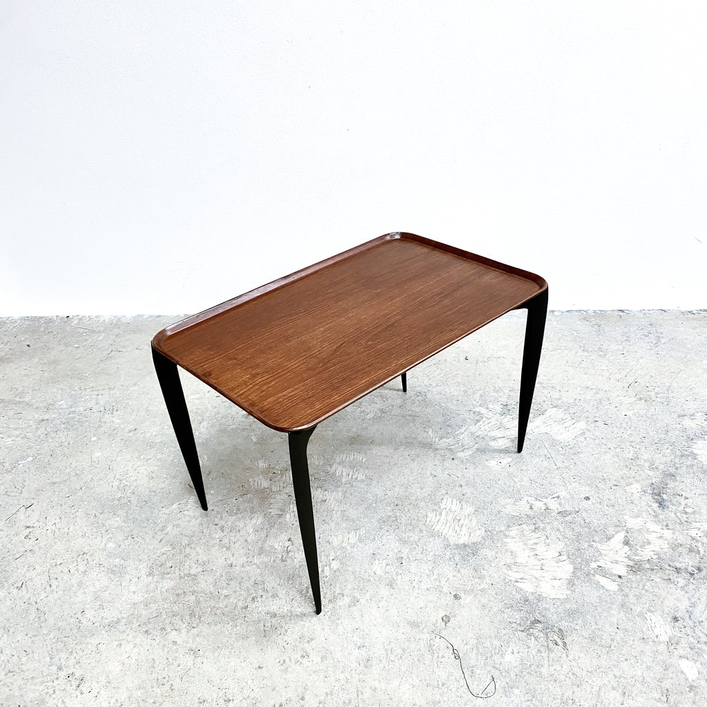 Wooden coffee table with black legs on a light gray floor