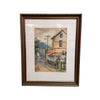 A framed watercolor painting of a quiet street scene with old houses, a dirt road, and utility poles, set in a dark brown ornate frame against a white wall.