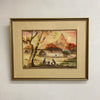 Framed artwork of a landscape scene with people and a tree on a white wall.