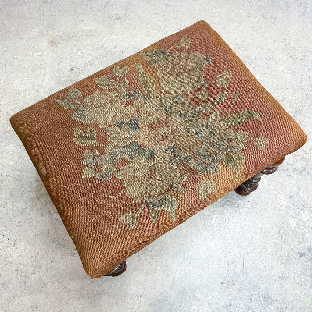 Small ottoman with floral pattern on a light gray background