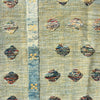 A close-up of a woven textile with a light beige base, a vertical blue stripe, and scattered multicolored oval motifs.