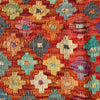 A close-up of a woven textile with a dense floral pattern in warm reds, oranges, cream, teal, purple, and gray.