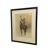 A framed vintage art print depicting a jockey riding a horse and waving, set in a dark brown frame with a cream mat, leaning against a white wall on a concrete floor.