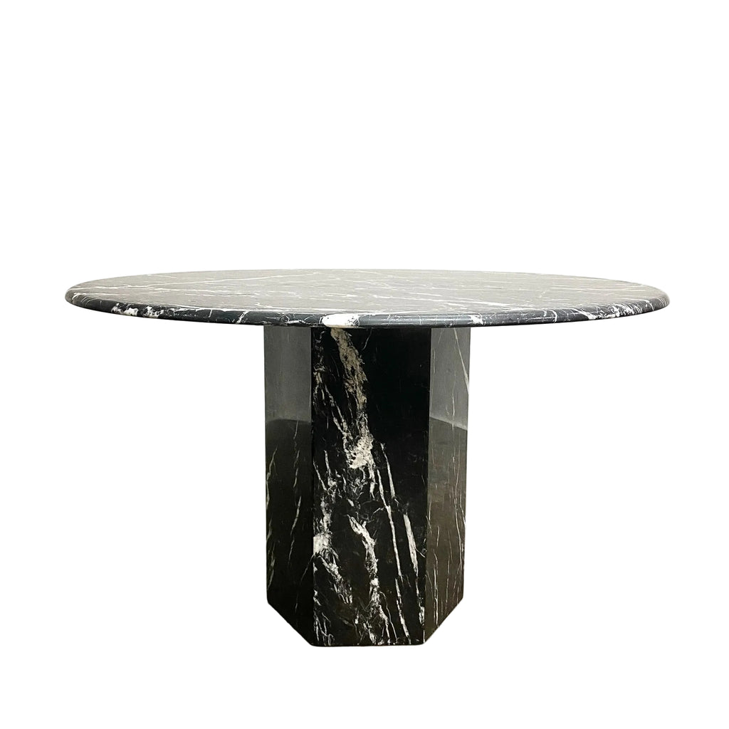 Round marble table with a black and white marbled design on a light gray background