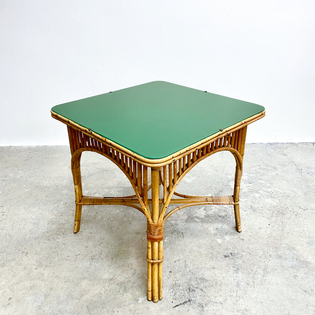 Wicker side table with a green top on a light gray background