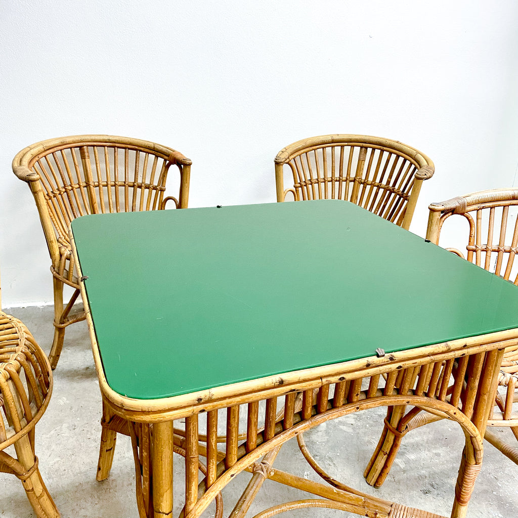 Rattan chairs and table with a green top on a light background