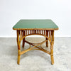 Green table with a wicker frame on a concrete floor