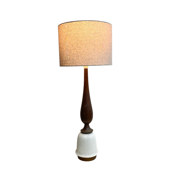 Table lamp with a wooden base and textured white shade on a white background