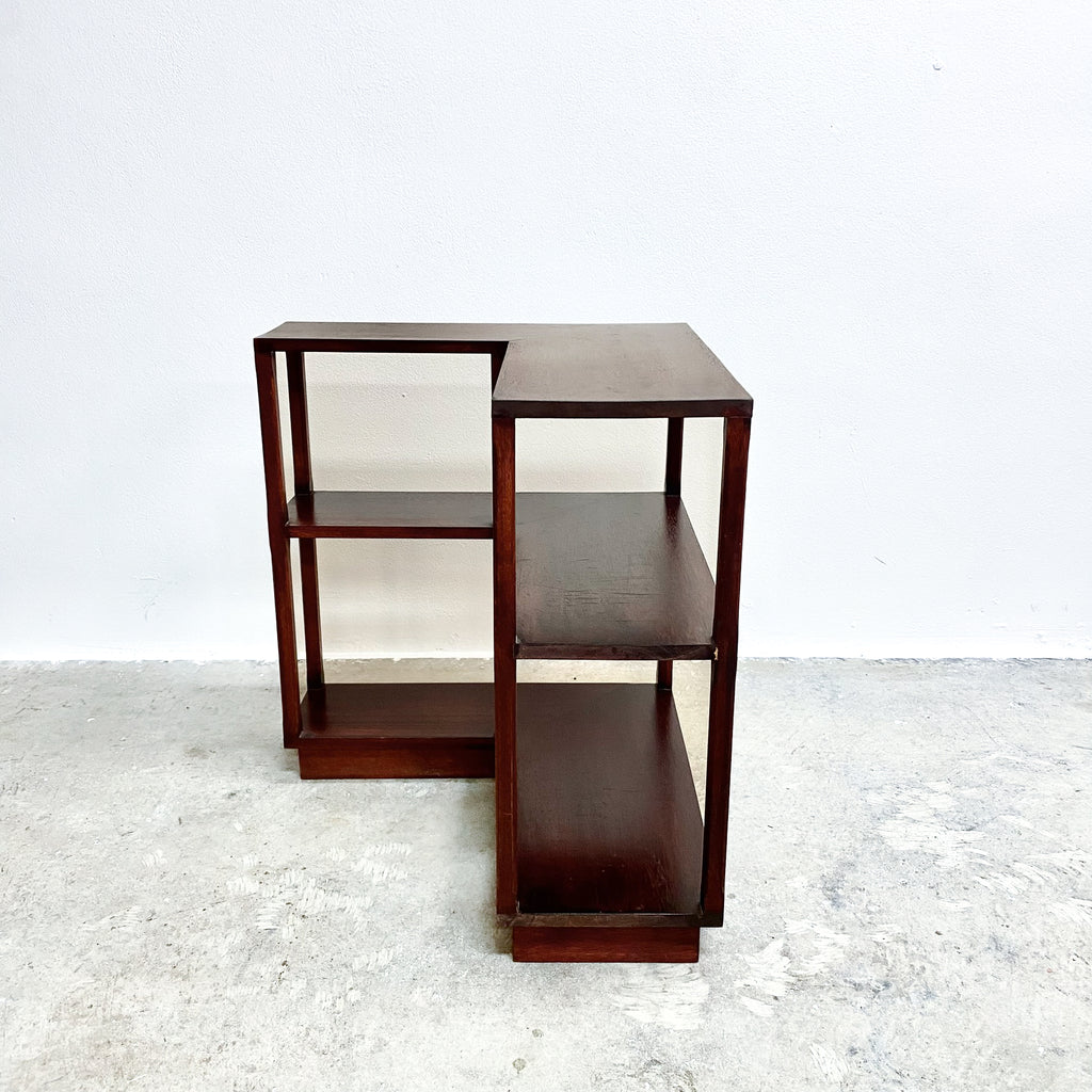 Set of three wooden side tables on a textured white surface with a light gray background