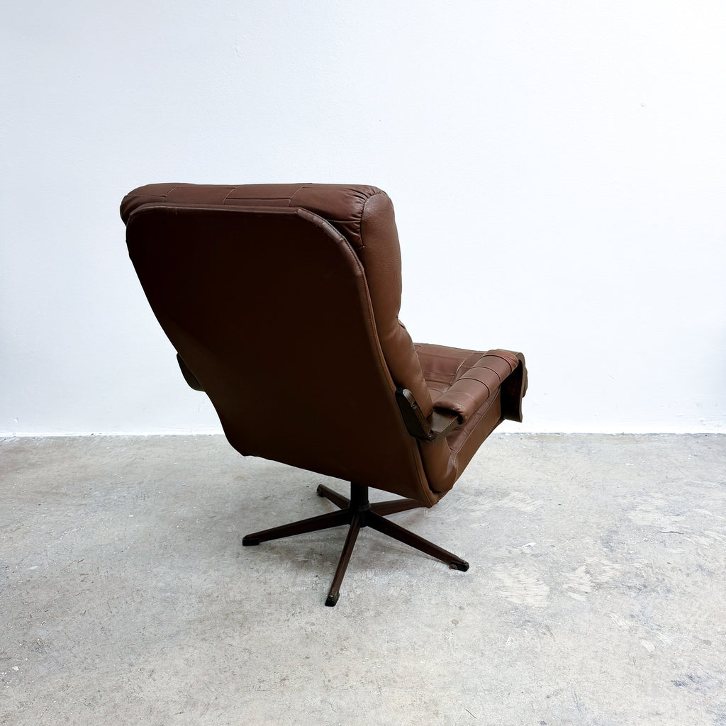 Brown leather swivel chair on a gray floor with a white wall background