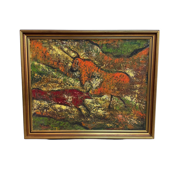 A framed painting depicting a prehistoric scene with two bulls on rocky terrain, rendered in earthy red, orange, green, and brown tones, enclosed in a gold frame and leaning against a white wall on a concrete floor.