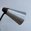 A vintage-style industrial metal lamp shade made of brushed silver aluminum, featuring a dark brown conical neck and a dark brown corrugated cord, shown against a plain light gray background.