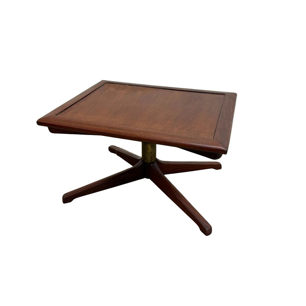 A mid-century modern square wooden side table with a star base and brass pedestal, photographed on a concrete floor against a white wall.