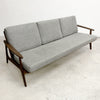 Gray sofa with wooden frame on a white floor