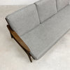 Gray sofa with wooden armrests on a light gray floor