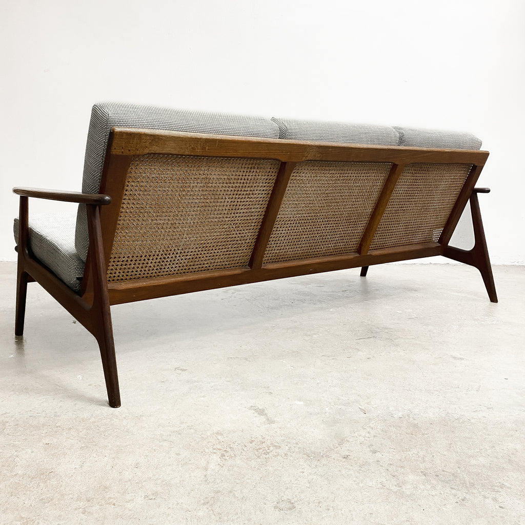 Wooden sofa with wicker backrest on a white background