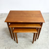 Set of three wooden nesting tables on a concrete floor