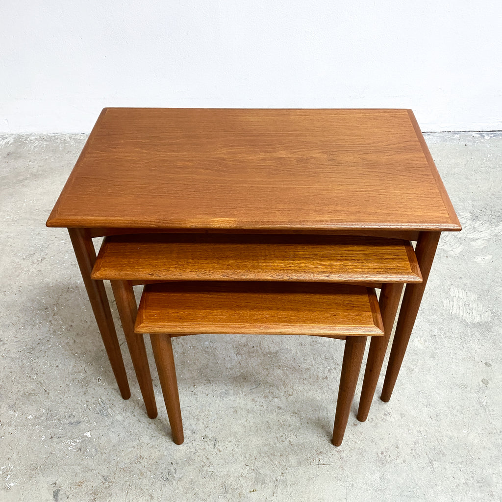 Set of three wooden nesting tables on a concrete floor