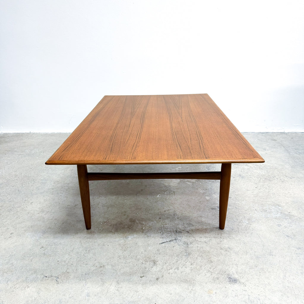 Wooden table on a light gray floor with a white background