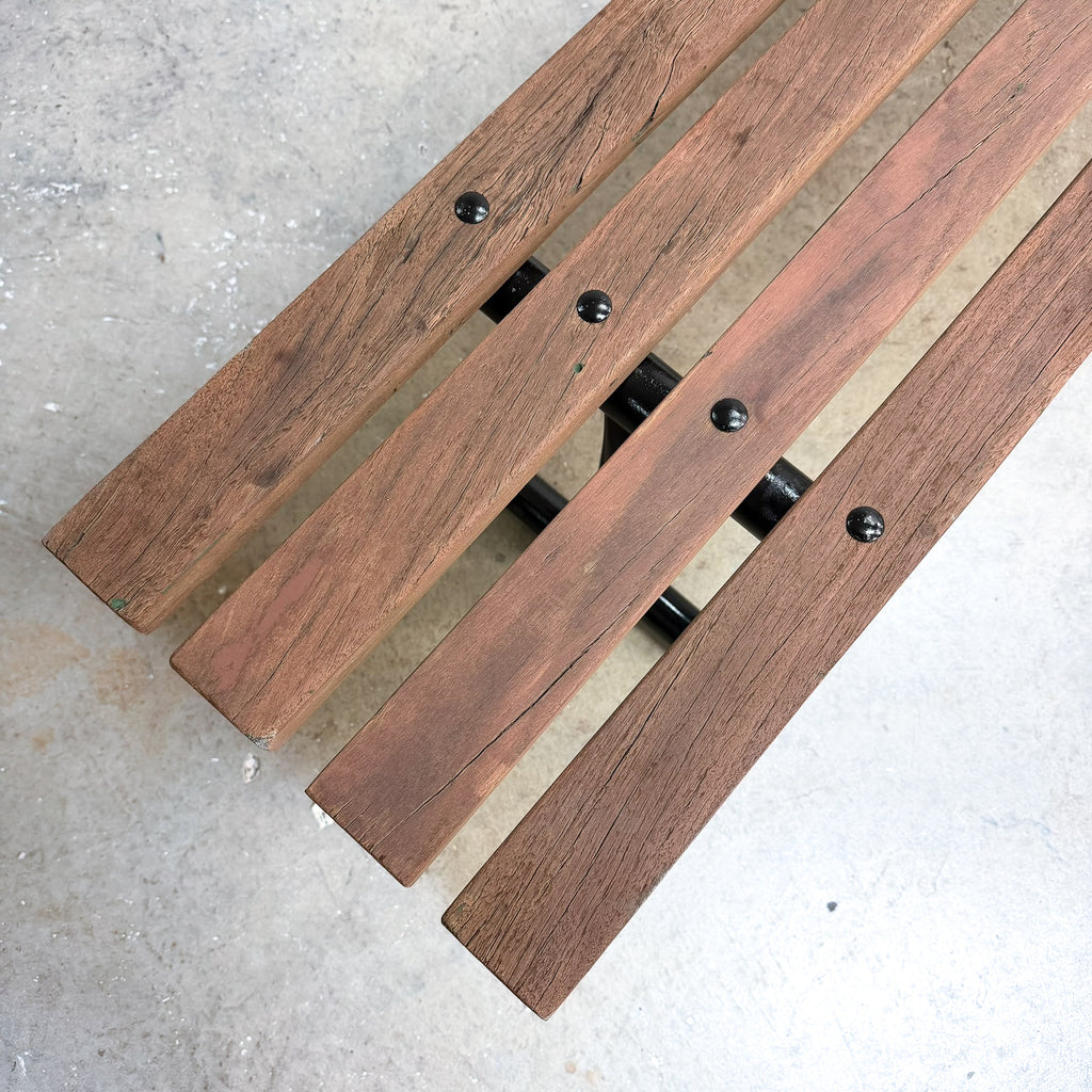 Wooden bench with metal brackets on a concrete surface