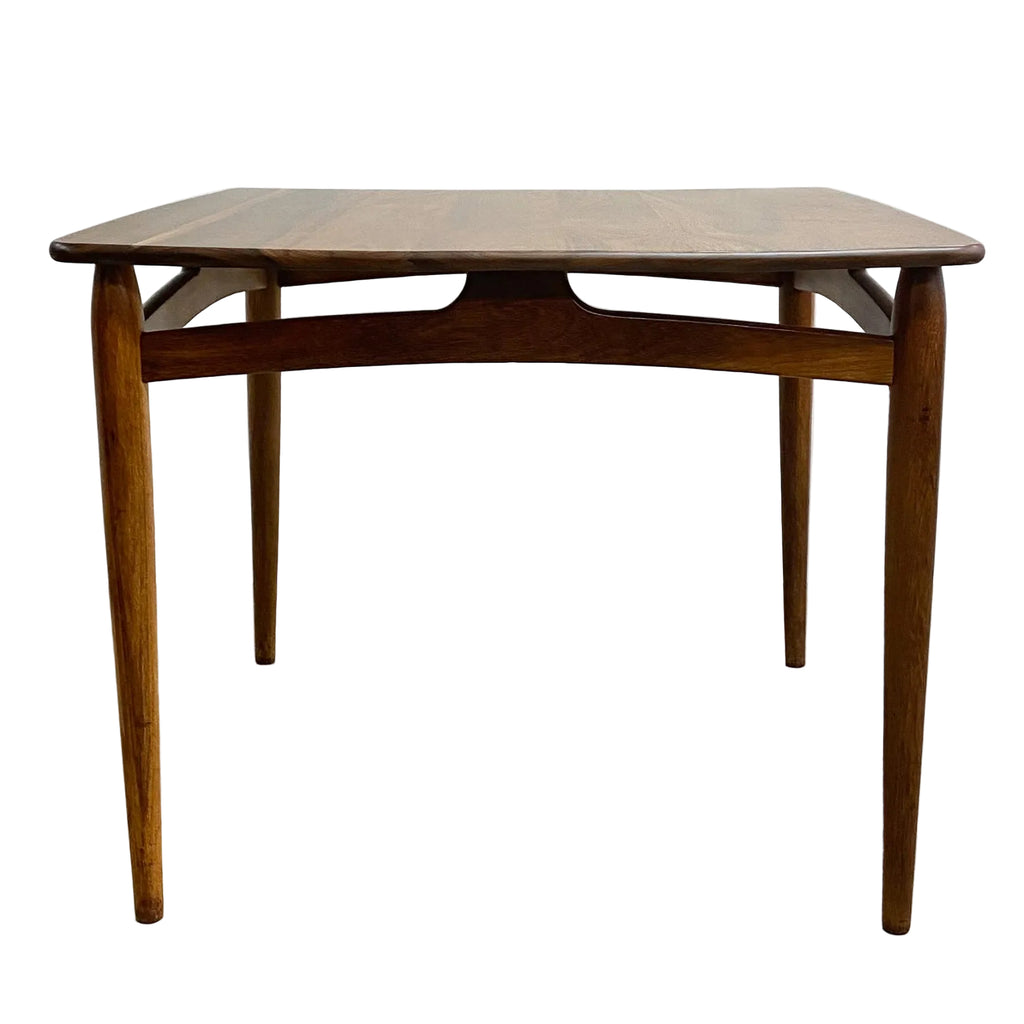 Wooden table with a curved top on a light gray background