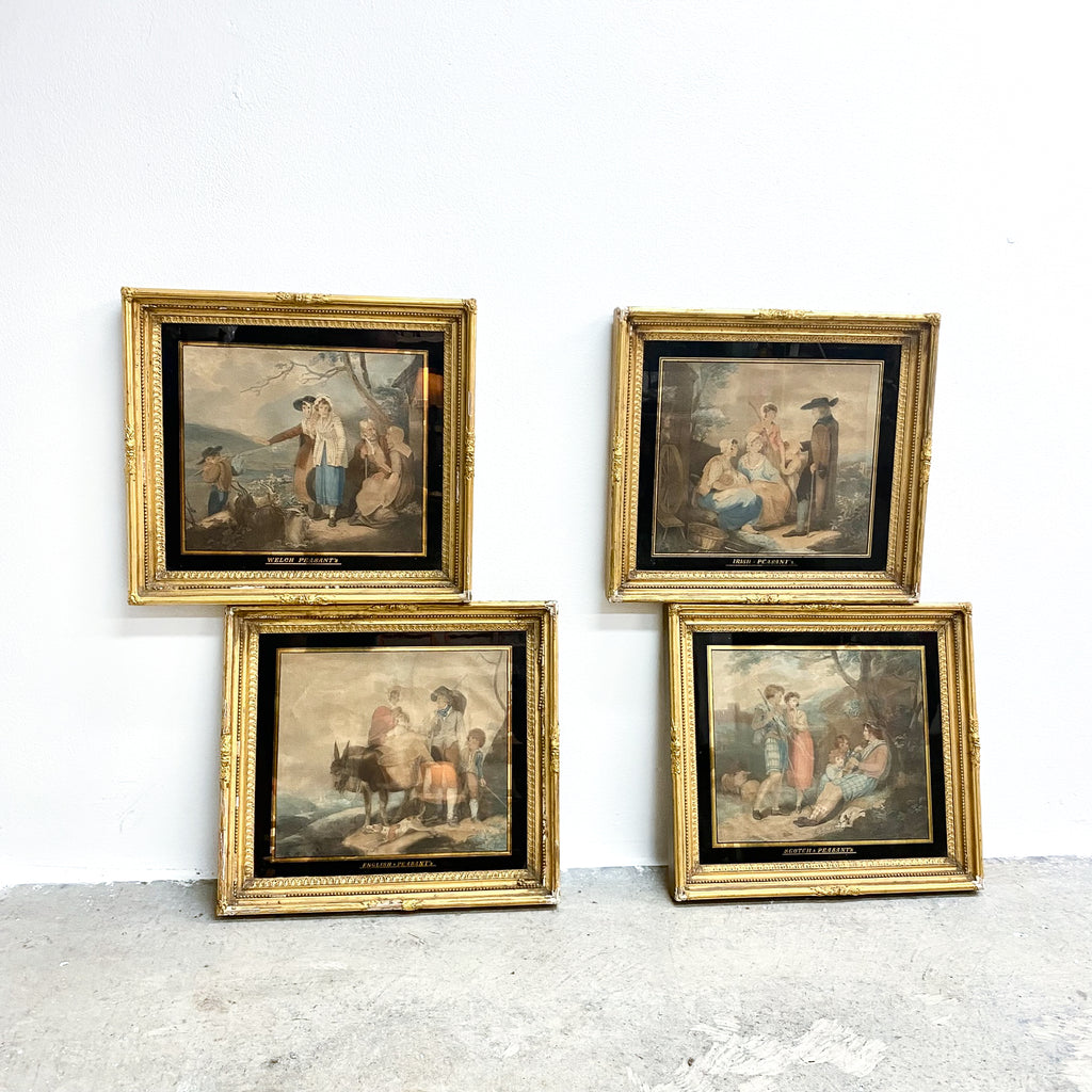 Four framed paintings with gold frames on a white wall.