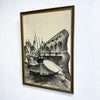 Framed artwork of a cityscape with a bridge and boat on a white wall