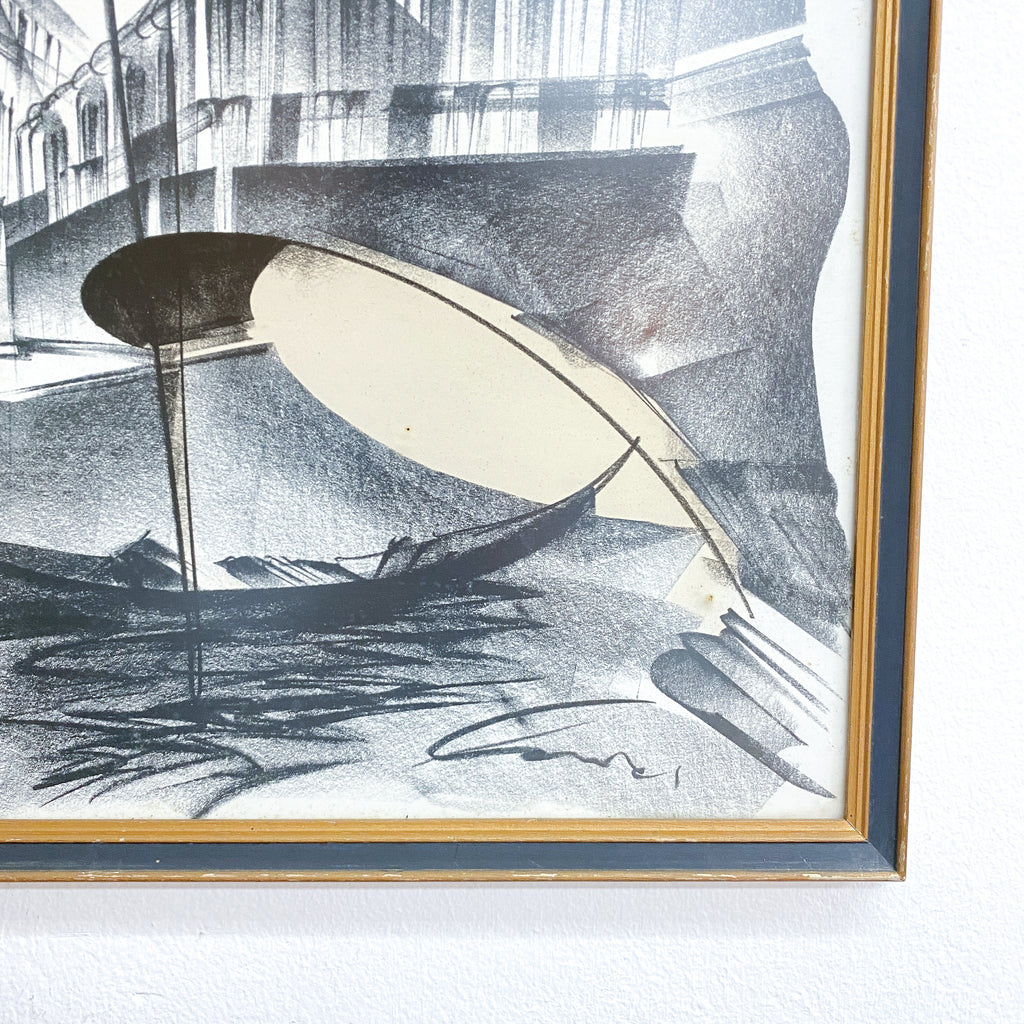 Framed black and white artwork of a boat on water with a bridge in the background.