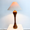 Table lamp with a wooden base and white shade on a light blue background