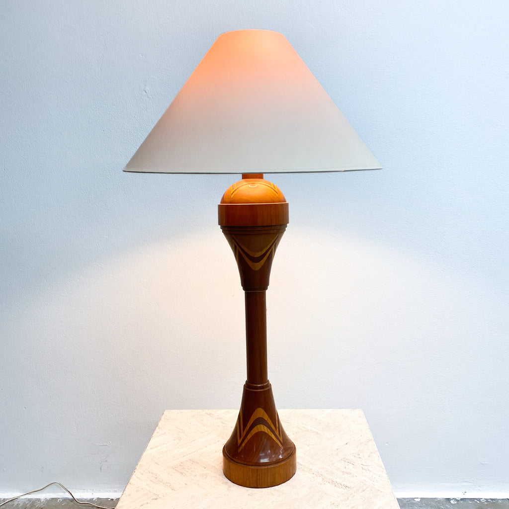 Table lamp with a wooden base and white shade on a light blue background