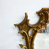 Decorative gold wall bracket against a white wall