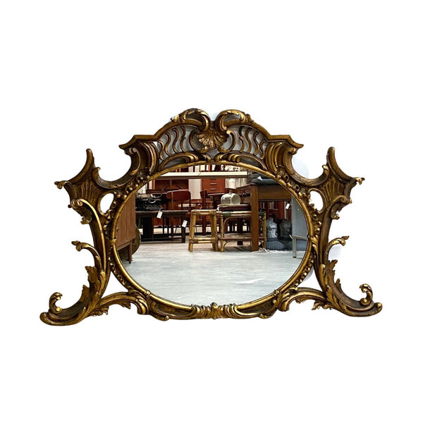 Decorative gold mirror with intricate designs on a white background