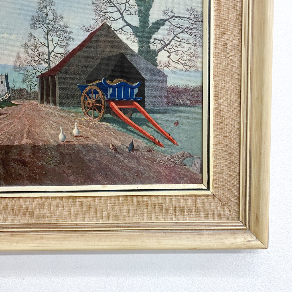 Framed artwork of a cart and building scene with a gold frame.