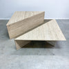 Beige stone coffee table on a concrete floor with a light gray wall background