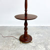 Wooden floor lamp on a textured surface with a white background
