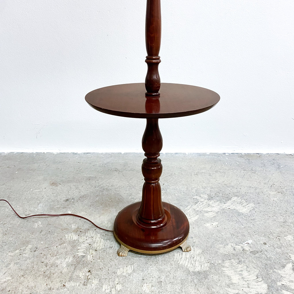 Wooden floor lamp on a textured surface with a white background