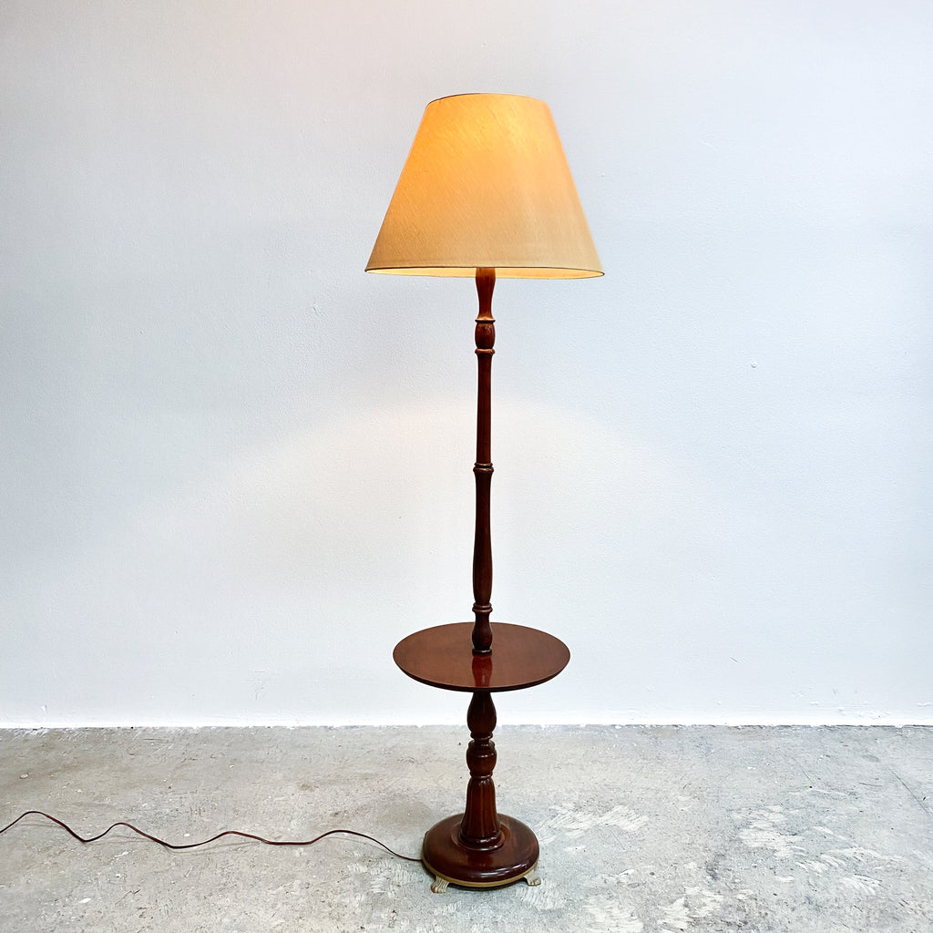 Wooden floor lamp with a beige shade on a plain white background