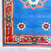 Close-up of a blue and red patterned rug corner